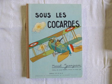 Couverture de Sous les cocardes. scènes de l'aviation militaire. texte et dessins de marcel jeanjean. p., éd. s. e. r. m. a., 1964 , in-4, demi-toile, plats cart. ill. en coul.